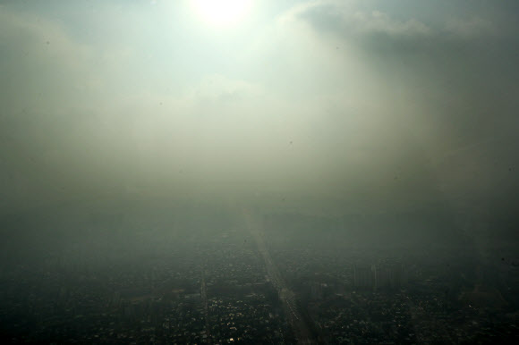 미세먼지 농도가 ’나쁨’ 수준을 보인 8일 오전 서울 송파구 잠실 롯데월드타워에서 바라본 서울 시내가 뿌연 모습을 보이고 있다.  연합뉴스