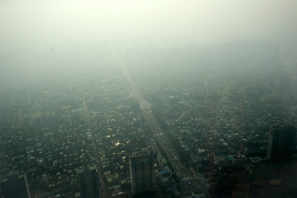 미세먼지 농도가 ’나쁨’ 수준을 보인 8일 오전 서울 송파구 잠실 롯데월드타워에서 바라본 서울 시내가 뿌연 모습을 보이고 있다.  연합뉴스