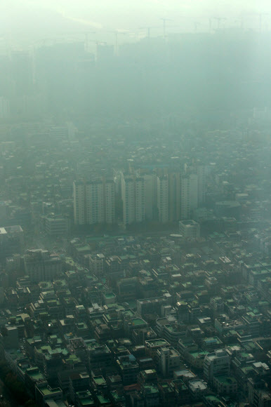 미세먼지 농도가 ’나쁨’ 수준을 보인 8일 오전 서울 송파구 잠실 롯데월드타워에서 바라본 서울 시내가 뿌연 모습을 보이고 있다.  연합뉴스