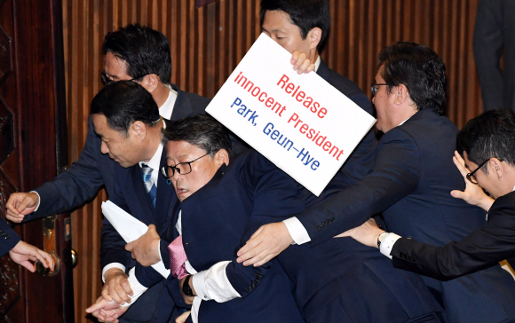 도널드 트럼프 미국 대통령이 8일 오전 국회 본회의장에서 1993년 7월 빌 클린턴 대통령에 이어 24년 만에 국회연설을 하기 입장 전 조원진 의원이 박근혜 전 대통령의 석방구호가 든 피켓을 들고 고함치자 경위들이 제지하고 있다. 2017. 11. 08  이종원 선임기자 jongwon@seoul.co.kr