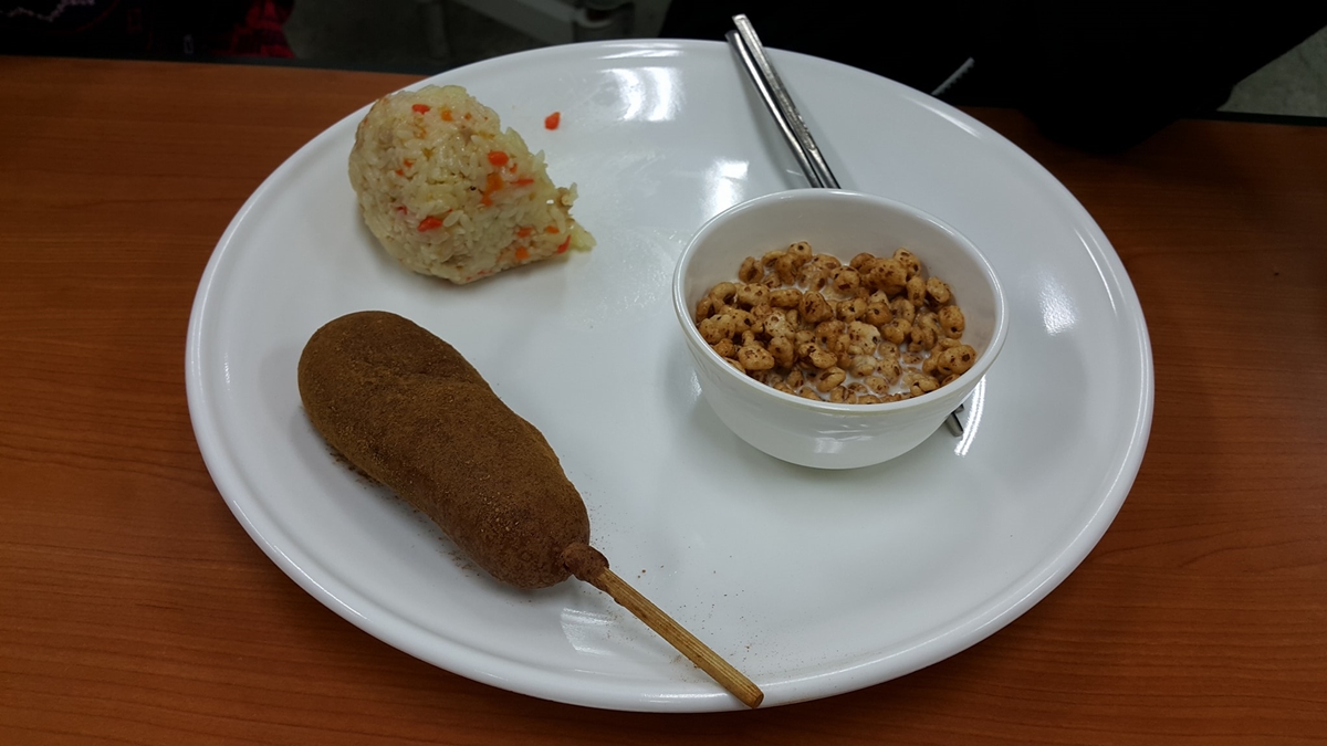 경기도 한 공립고등학교의 부실한 급식. 죠리퐁으로 보이는 쌀튀김 과자와 핫도그, 주먹밥이 전부다.  페이스북