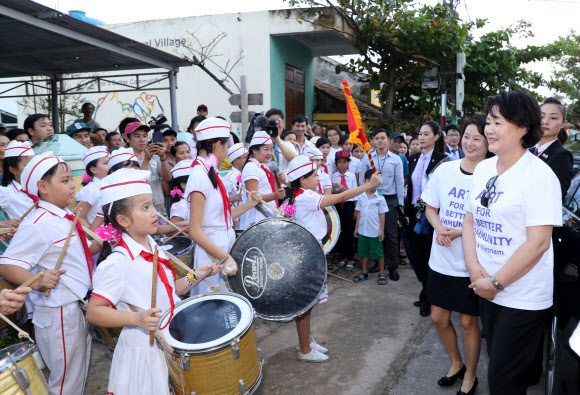 문재인 대통령 부인 김정숙 여사가 10일 오후 베트남 땀끼시 땀따잉 벽화마을을 방문, 이마을 학생들의 환영행사를 바라보고 있다. 땀따잉 벽화마을은 지난해 6월 한국과 베트남이 공동으로 완성했으며 한국의 공공미술 작가, 자윈봉사자, 마을 주민들이 힘을 모아 120여 가구의 벽면과 담장을 칠하고 벽화를 그린 한국식 벽화마을이다.  연합뉴스