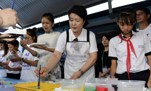 문재인 대통령 부인 김정숙 여사가 10일 오후 (현지시간) 베트남 땀끼시 땀따잉. 벽화마을을 방문, 채색체험하고 잇다.  땀따잉 벽화마을은 지난해 6월 한국국제교류재단과 땀끼시, 유엔 해비타트 베트남이  공동으로 기획하고  한국의 이강준 공공미술연구소가 시행하였으며 노루표 페인트가 협찬한 한국식 벽화마을이다.  연합뉴스
