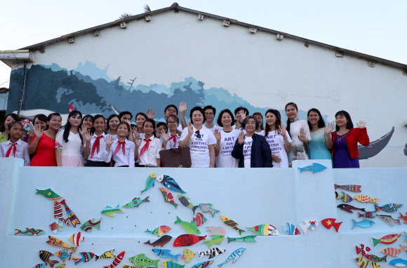 문재인 대통령 부인 김정숙 여사가 10일 오후 베트남 땀끼시 땀따잉 벽화마을을 방문, 벽화 보수작업을 마치고 기념촬영 하고 있다. 땀따잉 벽화마을은 지난해 6월 한국과 베트남이 공동으로 완성했으며 한국의 공공미술 작가, 자윈봉사자, 마을 주민들이 힘을 모아 120여 가구의 벽면과 담장을 칠하고 벽화를 그린 한국식 벽화마을이다. 연합뉴스