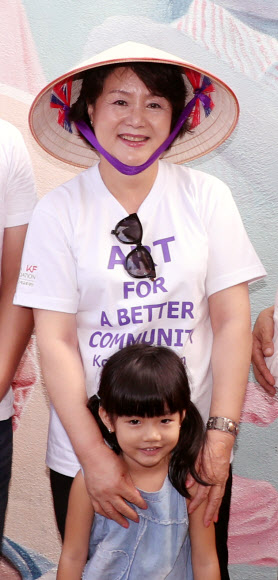 문재인 대통령 부인 김정숙 여사가 10일 오후 베트남 땀끼시 땀따잉 벽화마을을 방문, 벽화가 그려진 가족과 기념촬영하고 있다. 땀따잉 벽화마을은 지난해 6월 한국과 베트남이 공동으로 완성했으며 한국의 공공미술 작가, 자윈봉사자, 마을 주민들이 힘을 모아 120여 가구의 벽면과 담장을 칠하고 벽화를 그린 한국식 벽화마을이다.  연합뉴스