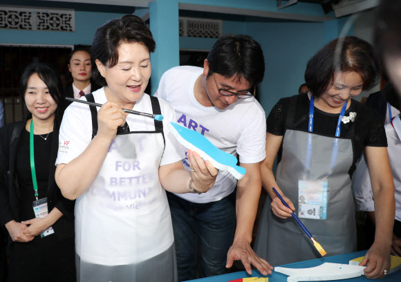 문재인 대통령 부인 김정숙 여사가 10일 오후 베트남 땀끼시 땀따잉 벽화마을을 방문, 벽화 보수작업을 함께 하고 있다. 땀따잉 벽화마을은 지난해 6월 한국국제교류재단과 땀끼시, 유엔 해비타트 베트남이 공동으로 기획하고 한국의 이강준 공공미술연구소가 시행하였으며 노루표 페인트가 협찬한 한국식 벽화마을이다.  연합뉴스