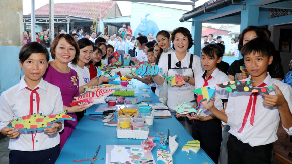 문재인 대통령 부인 김정숙 여사가 10일 오후 베트남 땀끼시 땀따잉 벽화마을을 방문, 벽화 작품을 마치고 기념촬영 하고 있다. 땀따잉 벽화마을은 지난해 6월 한국과 베트남이 공동으로 완성했으며 한국의 공공미술 작가, 자윈봉사자, 마을 주민들이 힘을 모아 120여 가구의 벽면과 담장을 칠하고 벽화를 그린 한국식 벽화마을이다.  연합뉴스