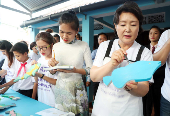 문재인 대통령 부인 김정숙 여사가 10일 오후 베트남 땀끼시 땀타잉 벽화마을을 방문, 직접 벽화에 사용할 그림 타일을 만들고 있다. 땀타잉 벽화마을은 지난해 6월 한국과 베트남이 공동으로 완성했으며 한국의 공공미술 작가, 자윈봉사자, 마을 주민들이 힘을 모아 120여 가구의 벽면과 담장을 칠하고 벽화를 그린 한국식 벽화마을이다.  연합뉴스