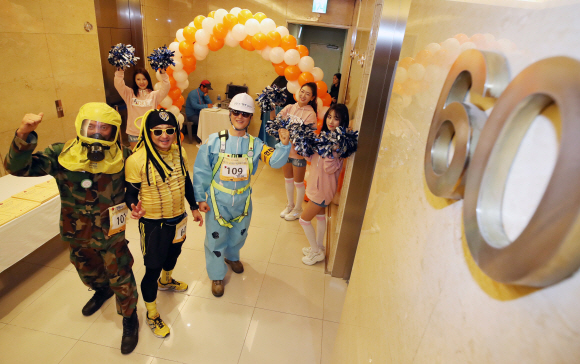 12일 오전 서울 여의도 63빌딩에서 열린 ’제15회 63빌딩 계단오르기 대회’에서 이색복장을 한 참가자들이 60층에 도착한 뒤 포즈를 취하고 있다. 2017.11.12 도준석 기자 pado@seoul.co.kr