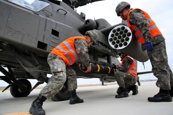 육군항공작전사령부 소속 아파치 가디언(AH-64E) 공격헬기가 전북 군산 앞바다 직도사격장에서 ’헬파이어’ 미사일 첫 사격을 실시한 13일 군인들이 헬파이어 미사일을 아파치 헬기에 장착하고 있다.  육군 제공=연합뉴스