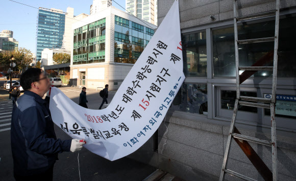 대학수학능력시험이 연기된 16일 오전 이화여자외국어고등학교에서 학교 관계자가 수능시험장 현수막을 철거하고 있다.  연합뉴스