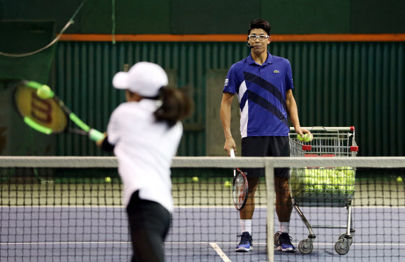 한국 테니스의 간판 스타 정현(오른쪽)이 17일 서울 송파구 한국체대 실내 테니스장에서 초등학교 유망주를 대상으로 원 포인트 레슨을 하고 있다. 연합뉴스