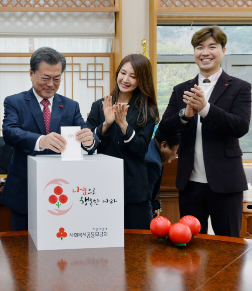 문재인 대통령이 20일 청와대 여민관 집무실에서 열린 ’사랑의열매 전달식’에서 사랑의열매를 전달받은 후 성금을 모금함에 넣고 있다. 오른쪽은 사회복지공동모금회 홍보대사인 배우 채시라씨와 개그맨 박수홍씨. 2017. 11. 20 안주영 기자 jya@seoul.co.kr