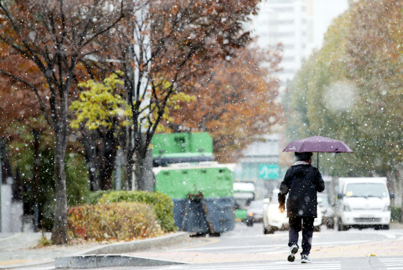 20일 오후 서울 용두역 근처에서 시민이 내리는 눈을 맞으며 걷고 있다.  연합뉴스