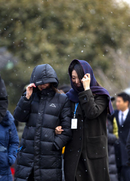 서울에 눈이 온 20일 오후 광화문광장에서 시민들이 눈을 맞으며 길을 걷고 있다.  연합뉴스