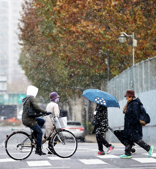 20일 오후 서울 용두역 근처에서 시민이 내리는 눈을 맞으며 걷고 있다.  연합뉴스