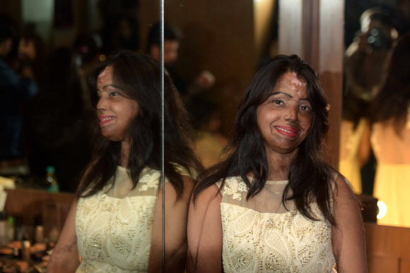 25일(현지시간) 인도 뉴델리에서 열린 비정부단체 ‘상처  아닌 사랑을 만들자(Make Love Not Scars)’가 주최한 패션쇼에서 산성물질 공격을 당해 얼굴에 상처를 입은 인도 여성들이 모델로 무대에 올랐다. AFP 연합뉴스