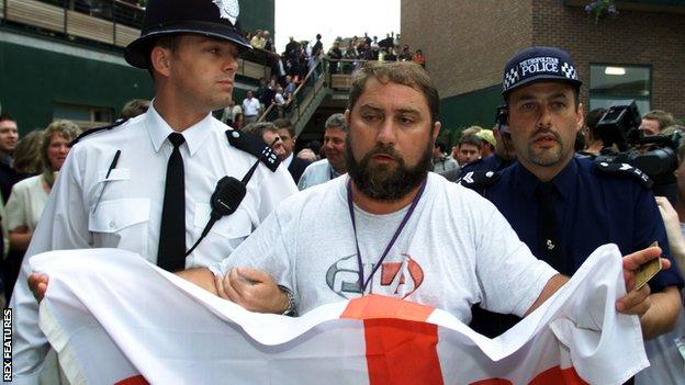   다미르 도키치가 2000년 윔블던 대회 때 세인트조지 깃발을 든 채 응원하다 경호요원들에 의해 끌려나오고 있다. 세인트조지 깃발은 영국연방 가운데 잉글랜드인들이 국기로 여기고 있어 윔블던 대회에서는 펼치지 못하도록 돼 있다. 렉스 피처스 자료사진 