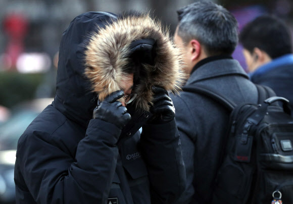 서울 아침기온 영하 7도의 매서운 추위가 찾아온 11일 오전 두꺼운 옷차림을 한 출근길 시민들이 광화문 네거리를 지나고 있다.  연합뉴스