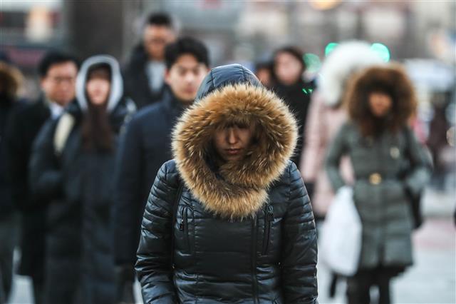 전국이 영하권에 드는 강추위가 시작된 11일 오전 서울 광화문 광장에서 출근길 시민들이 발걸음을 재촉하고 있다.  기상청은 ”당분간 기온은 큰 폭으로 떨어지고 내륙은 최저기온이 영하 10도 이하까지 떨어져 건강관리에 유의해야 한다”고 밝혔다.  뉴스1
