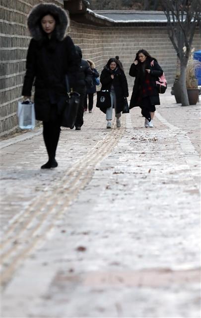 올 겨울 들어 가장 추운 날씨를 보인 11일 오전 빙판으로 변한 서울 중구 정동 덕수궁 돌담길에서 등굣길 학생들이 엉금엉금 걷고 있다. 뉴스1