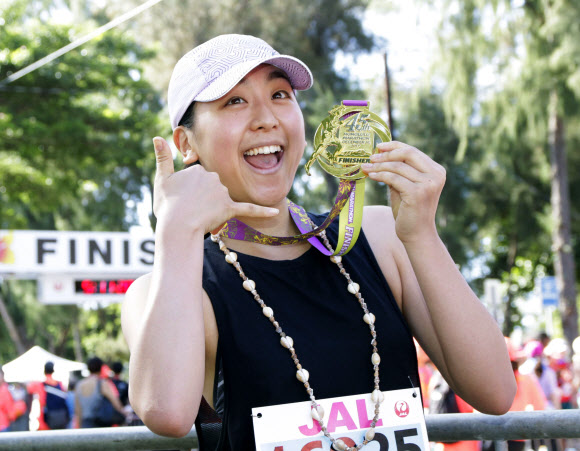 ’김연아의 라이벌’로 은반에서 경쟁하다 현역에서 은퇴한 일본 피겨스케이팅 여자 싱글 ’간판’ 아사다 마오가 10일(현지시간) 미국 하와이주 호놀룰루에서 열린 ’제45회 JAL 호놀룰루 마라톤’에서 4시간 34분 13초의 기록으로 완주한 뒤 메달을 보여주며 함박웃음 짓고 있다.  교도=연합뉴스