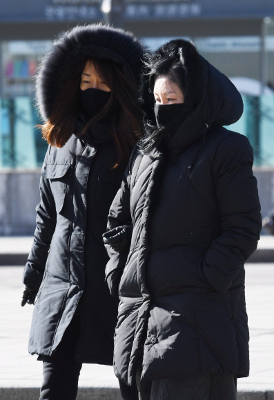 기온이 하루 종일 영하권에 머물며 매서운 추위가 닥친 11일 서울 종로구 광화문네거리에서 두꺼운 옷차림을 한 시민들이 차가운 겨울 바람을 맞으며 길을 걷고 있다. 2017. 12. 11 손형준 기자 boltagoo@seoul.co.kr