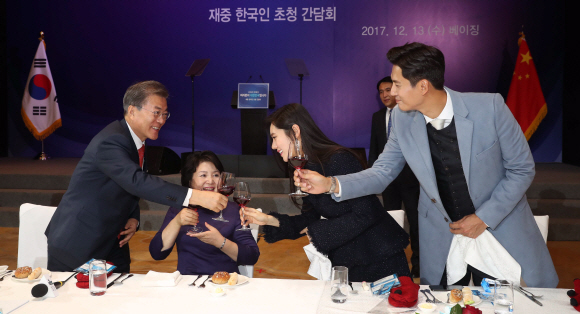 문재인 대통령과 부인 김정숙 여사가 13일 오후 중국 국빈방문 첫 일정으로 베이징에 위치한 완다 소피텔 호텔에서 열린 재중국 한국인 오찬 간담회에서 한인회장단, 독립유공자 후손, 한중 다문화 부부 등과 건배하고 있다. 오른쪽은 추자현-우효광 부부. 2017. 12. 13 안주영 기자 jya@seoul.co.kr