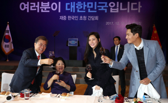 문재인 대통령과 부인 김정숙 여사가 13일 오후 중국 국빈방문 첫 일정으로 베이징에 위치한 완다 소피텔 호텔에서 열린 재중국 한국인 오찬 간담회에서 한인회장단, 독립유공자 후손, 한중 다문화 부부 등과 건배하고 있다. 오른쪽은 추자현-우효광 부부. 2017. 12. 13 안주영 기자 jya@seoul.co.kr