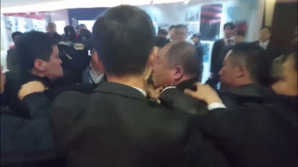 한국의 사진기자(목이 잡혀 있는 사람)가 14일 오전 베이징 국가회의중심(CNC) B홀에서 열린 문재인 대통령의 ‘한·중 경제무역 파트너십 개막식’에서 스타트업관으로 이동하는 길에 중국 측 경호원들에게 둘러싸여 일방적으로 폭행을 당하고 있다. CBS 노컷뉴스 제공