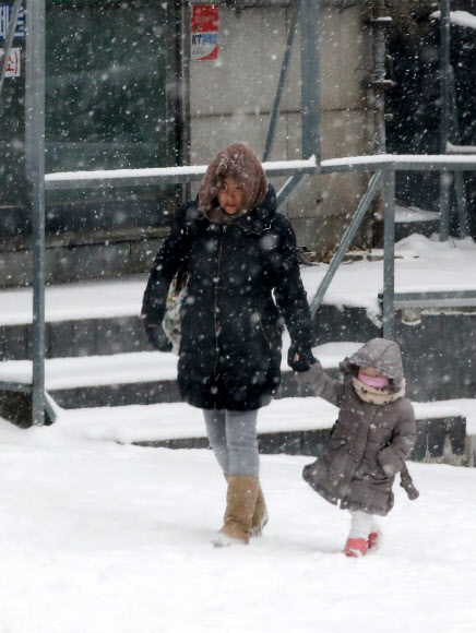 눈이 내린 18일 오전 중구 만리동에서 유치원생이 등교하고 있다.  연합뉴스