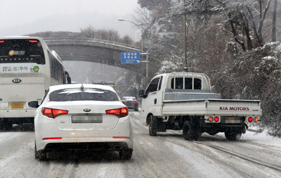눈이 내린 18일 오전 서울 중구 남산 1호터널 도로에서 차량이 미끄러져 이동을 못 하고 있다.  연합뉴스
