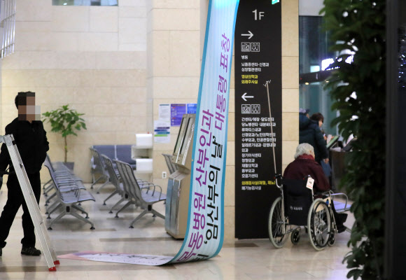 18일 오전 신생아 4명이 잇따라 숨진 사고가 발생한 서울 양천구 이대목동병원에 설치됐던 ’임산부의 날’ 대통령표창을 알리는 현수막이 철거되고 있다.  연합뉴스