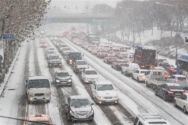 서울에 올겨울 첫 대설주의보가 내린 18일 양천구의 한 도로에 차량들이 정체되고 있다. 기상청에 따르면 이날 오전 10시까지 서울 지역에 쌓인 눈은 4.8?며, 밤까지 7cm 눈이 더 쌓일 것으로 예상된다.  뉴스1