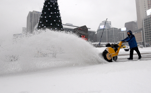 폭설이 내린 18일 서울 시청역에서 관계자들이 제설작업을 하고 있다.   2017.12.18  박지환 기자 popocar@seoul.co.kr