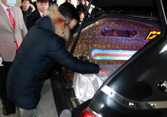 서울 양천구 이대목동병원에서 숨진 신생아의 장례 절차가 19일 진행됐다. 유가족이 관을 어루만지고 있다.  연합뉴스