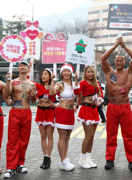 크리스마스를 사흘 앞둔 22일 오후 서울 중구 명동에서 ’몸짱산타’들이 장기기증 캠페인을 열고 있다.  연합뉴스