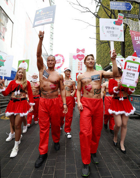 크리스마스를 사흘 앞둔 22일 오후 서울 중구 명동8길에서 ’몸짱산타’들의 장기기증 홍보 퍼레이드가 펼쳐지고 있다.  연합뉴스
