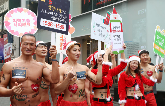 크리스마스를 사흘 앞둔 22일 오후 서울 중구 명동8길에서 ’몸짱산타’로 변신한 아놀드 홍 트레이너(왼쪽)을 비롯한 참가자들이 장기기증 홍보 퍼레이드를 펼치고 있다.  연합뉴스
