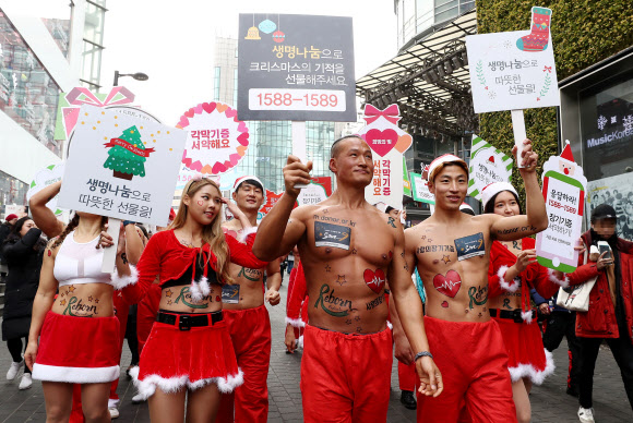 크리스마스를 사흘 앞둔 22일 오후 서울 중구 명동8길에서 ’몸짱산타’들의 장기기증 홍보 퍼레이드가 펼쳐지고 있다. 연합뉴스