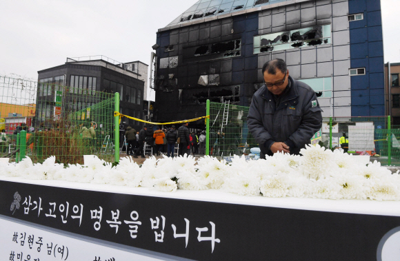 22일 충북 제천시 하소동 스포츠센터 화재현장에 마련된 추모 장소에서 한 시민이 희생자들을 추모하고 있다. 지난 21일 오후 화재가 발생해 현재까지 29명이 숨지고 31명이 입원 치료 중이다.2017. 12. 21.  박윤슬 기자 seul@seoul.co.kr