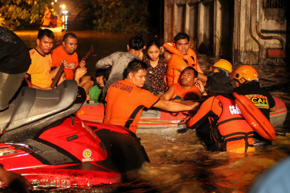 23일(현지시간) 태풍 ‘덴빈’으로 홍수와 산사태가 일어나 200여명이 사망한 필리핀 남부 민다나오섬 다바오에서 구조 요원들이 주민들을 대피시키고 있다. 성탄절을 앞두고 분쟁 지역에서 정전 선언이 잇따르는 등 지구촌의 평화를 기원하는 분위기 속에서도 테러 위협과 재해, 사고로 인한 인명피해는 끊이질 않고 있다. 다바오 AFP 연합뉴스