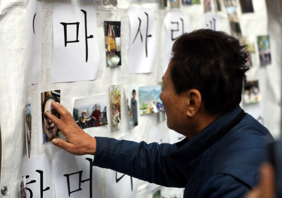 25일 오전 충북 제천 스포츠센터 화재 희생자 합동분향소에서 고 장경자씨의 64살 동갑내기 남편 김인동씨가 장씨의 사진을 어루만지고 있다. 2017.12.25 연합뉴스.