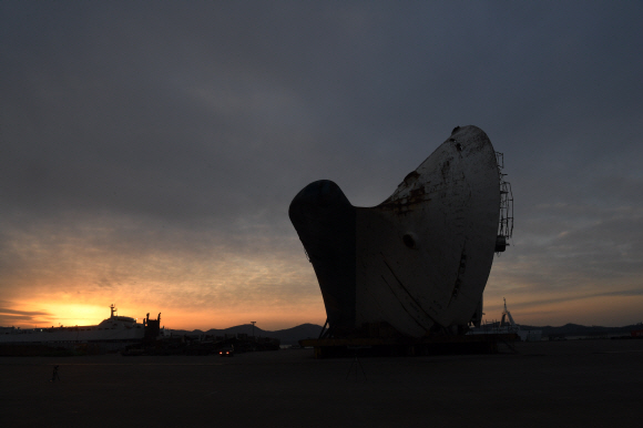 <송년기획> 2017년 오랜 기다림 끝에 뭍으로 올라온 세월호가 2018년 바로 선다. 지난 4월 인양한 세월호에서 7개월여간 수색작업을 진행한 현장수습본부가 내년 3월 선체 직립 전까지 수색을 잠정 중단하기로 해 세월호는 다시 기다림을 이어가고 있다. 사진은 지난 27일 밤에 세월호가 거치된 목포신항에서 촬영한 사진 수백 장을 합성한 세월호와 밤하늘 별들의 궤적이다. 2017.12.27 정연호 기자 tpgod@seoul.co.kr