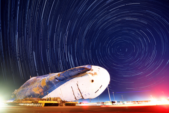 <송년기획> 2017년 오랜 기다림 끝에 뭍으로 올라온 세월호가 2018년 바로 선다. 지난 4월 인양한 세월호에서 7개월여간 수색작업을 진행한 현장수습본부가 내년 3월 선체 직립 전까지 수색을 잠정 중단하기로 해 세월호는 다시 기다림을 이어가고 있다. 사진은 지난 27일 밤에 세월호가 거치된 목포신항에서 촬영한 사진 수백 장을 합성한 세월호와 밤하늘 별들의 궤적이다. 2017.12.27 정연호 기자 tpgod@seoul.co.kr