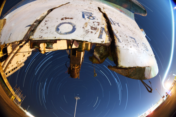 <송년기획> 2017년 오랜 기다림 끝에 뭍으로 올라온 세월호가 2018년 바로 선다. 지난 4월 인양한 세월호에서 7개월여간 수색작업을 진행한 현장수습본부가 내년 3월 선체 직립 전까지 수색을 잠정 중단하기로 해 세월호는 다시 기다림을 이어가고 있다. 사진은 지난 27일 밤에 세월호가 거치된 목포신항에서 촬영한 사진 수백 장을 합성한 세월호와 밤하늘 별들의 궤적이다. 2017.12.27 정연호 기자 tpgod@seoul.co.kr