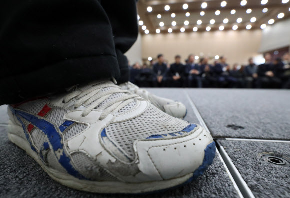 3일 오전 정부세종청사 세종컨벤션센터에서 열린 정부청사관리본부 신년행사에서 정규직으로 전환된 직원의 낡은 신발이 보이고 있다.  연합뉴스