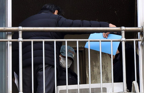 3일 오후 광주 북구 두암동 한 아파트에서 열린 현장검증에서 화재를 일으켜 세 남매를 숨지게한 혐의로 구속된 20대 엄마 정모씨가 당시 상황을 재연하고 있다.  연합뉴스