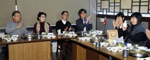 문재인 대통령이 7일 오전 서울 용산 CGV 내 한 식당에서 열린 블랙리스트 피해 문화예술인 간담회에서 참석자들과 얘기를 나누고 있다. 왼쪽부터 문 대통령, 부인 김정숙 여사, 신동옥 시인, 가수 백자, 서유미 소설가, 김서령 문화예술기획 이오공감 공동대표. 김 대표가 선물을 받고 있다. 20180107청와대사진기자단