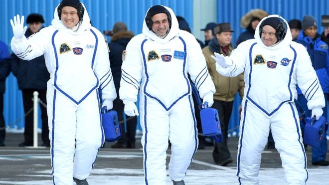 일본 우주인 가나이 노리시게(왼족)가 지난달 러시아 소유즈 우주선에 탑승해 국제우주정거장(ISS)으로 떠나기 전 손을 흔들어 답례하고 있다. 로이터 자료사진